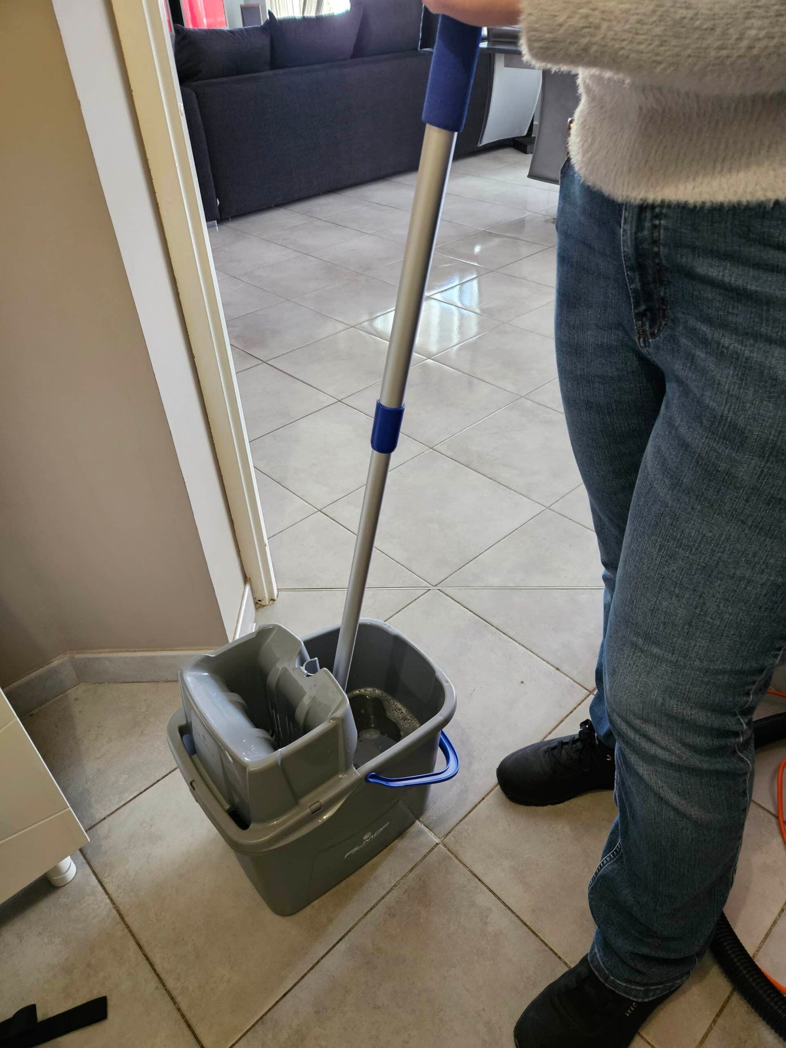 Nettoyage du sol d’un logement avec un balai et un seau à essorage