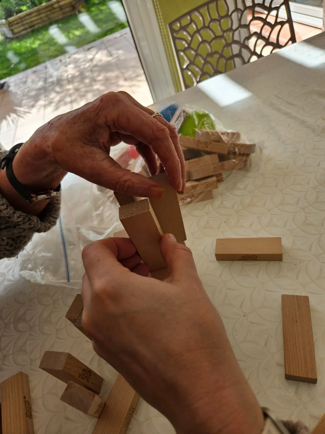 Mains de deux personnes partageant un jeu de construction en bois