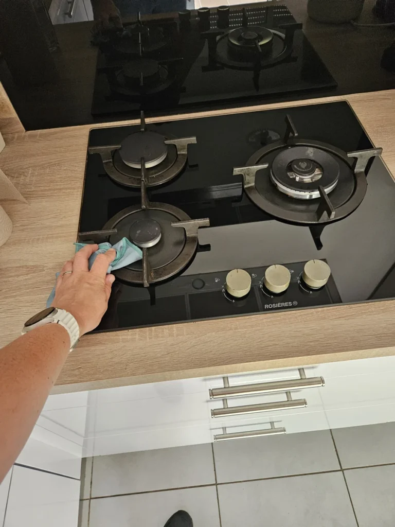 Nettoyage d’une plaque de cuisson avec un chiffon — photo réelle d’une intervention