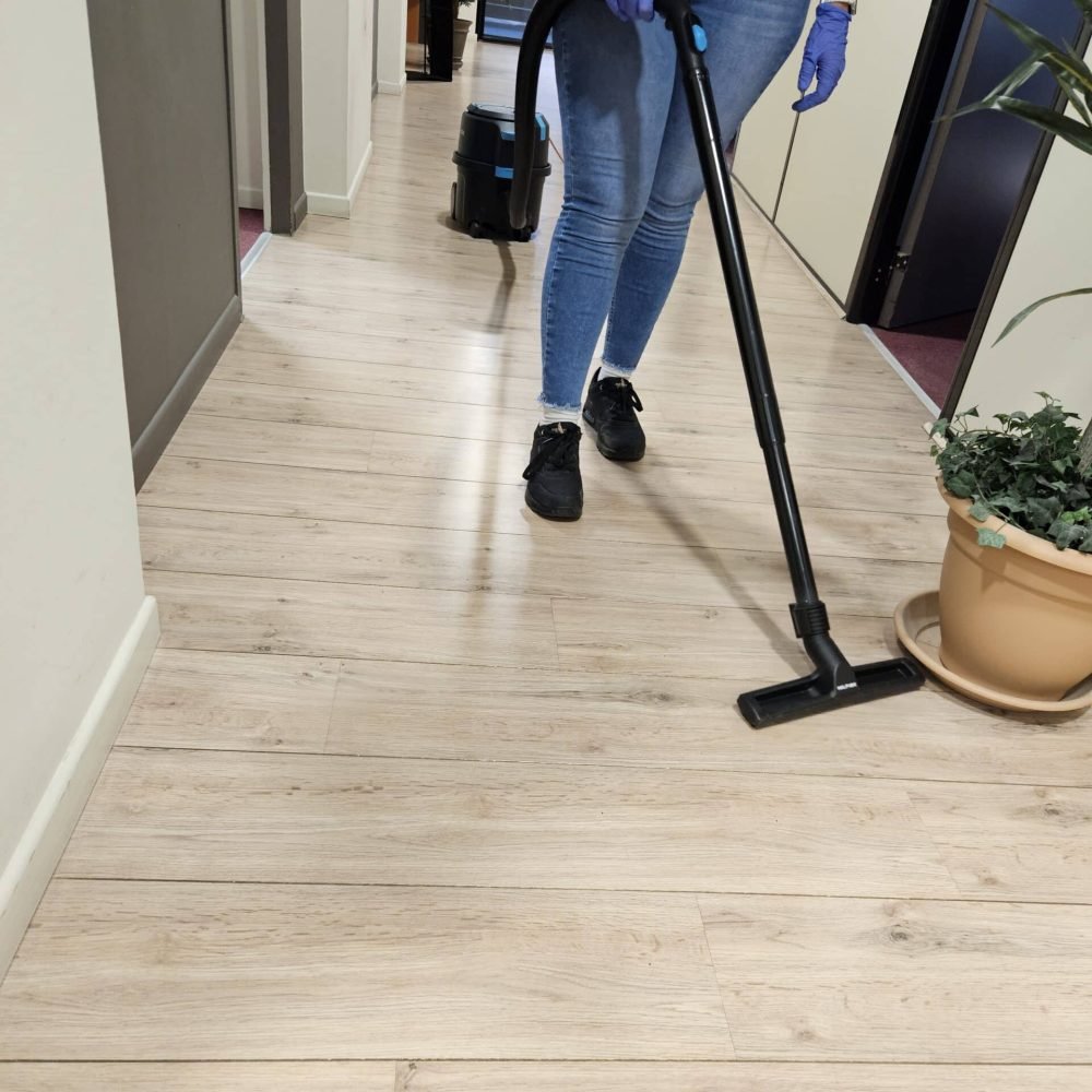 Intervenante passant l’aspirateur dans le couloir d’un logement